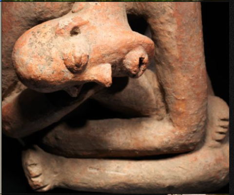 Statue of man curled in position of sadness